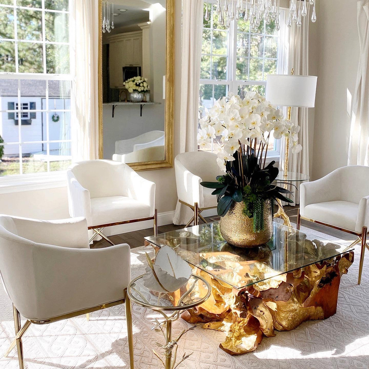 Delaney gold vase with multiple stems of Phalaenopsis orchids and succulents