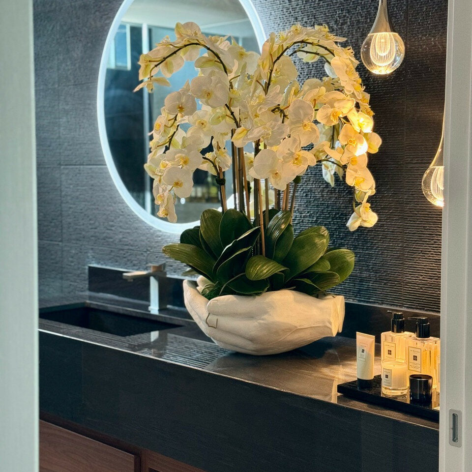 White Phalaenopsis orchids in a vase, open hand sculpture