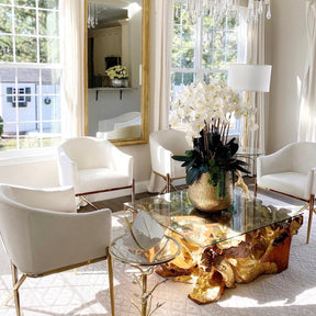 Delaney gold vase with multiple stems of Phalaenopsis orchids and succulents