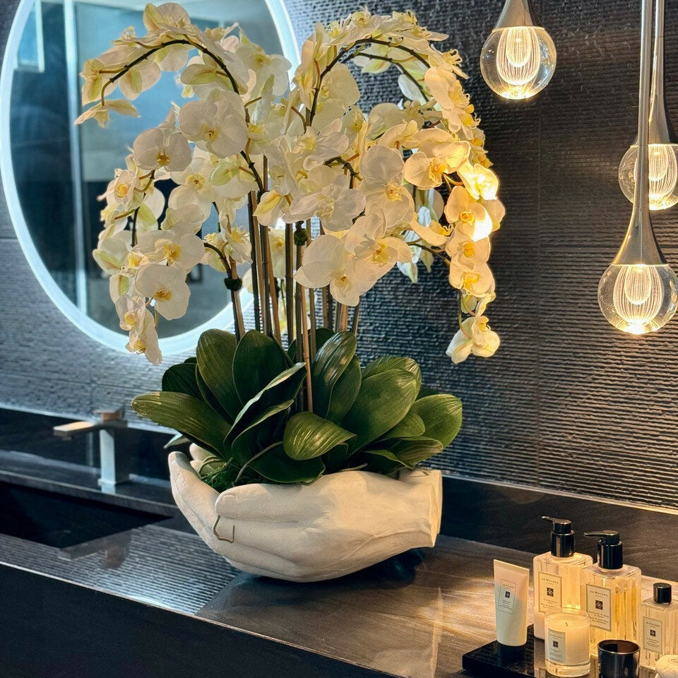 White Phalaenopsis orchids in a vase, open hand sculpture