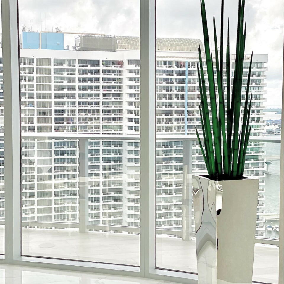 Stainless steel cube vase with snake grass