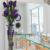 Purple Vanda orchids and driftwood in a conical glass cylinder