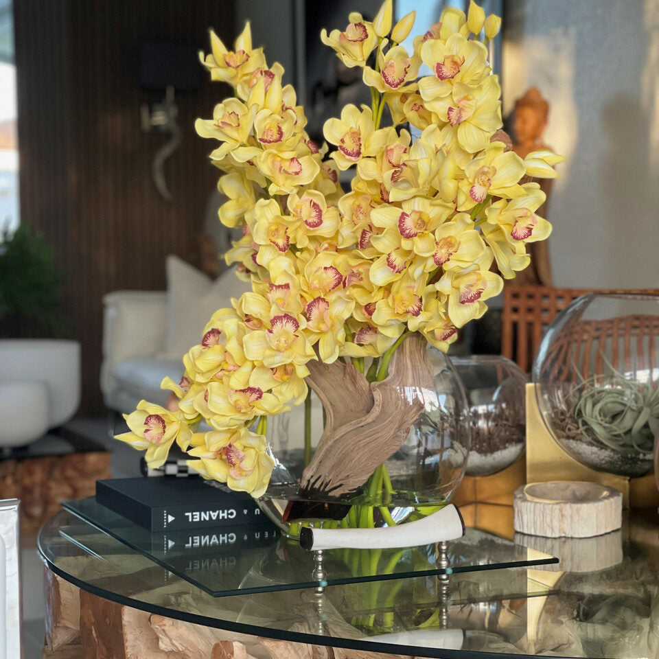 Yellow cymbidiums in a moon vase