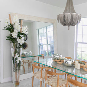 White Vanda orchids and driftwood in a large conical glass cylinder