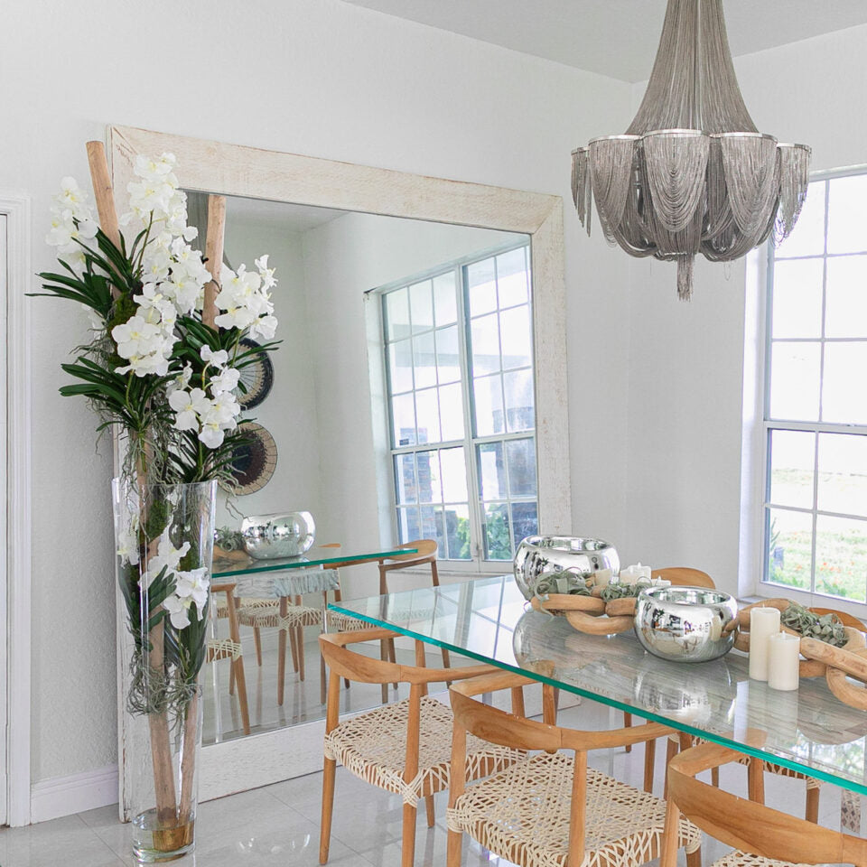 White Vanda orchids and driftwood in a large conical glass cylinder