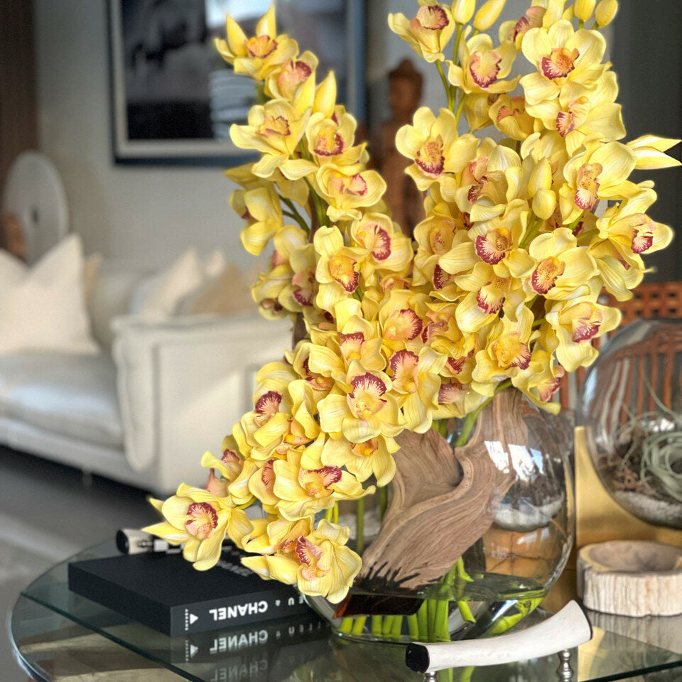 Yellow cymbidiums in a moon vase